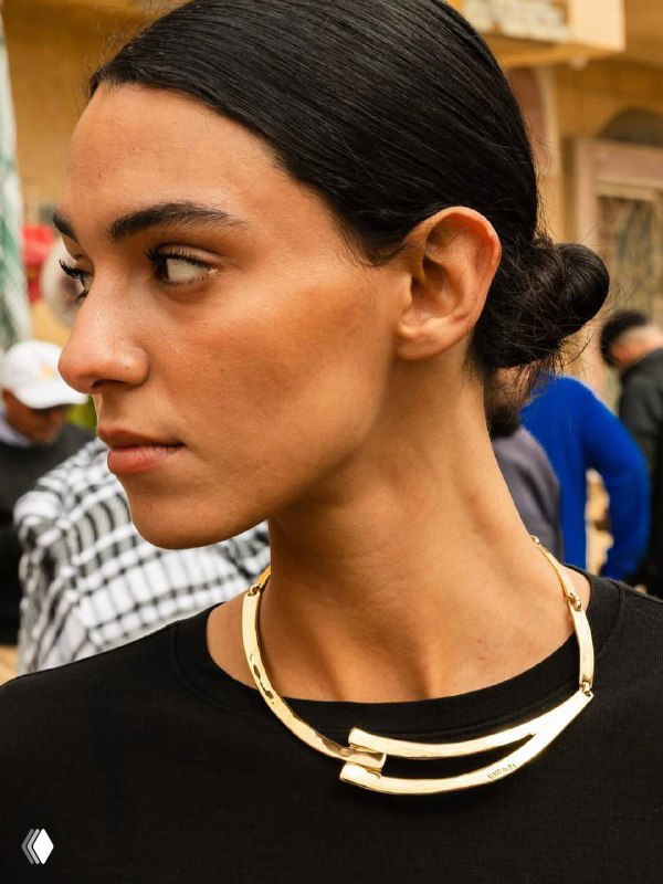 Портрет женщины с короткой причёской и золотым колье, строгая подача украшения в уличном стиле для летней коллекции