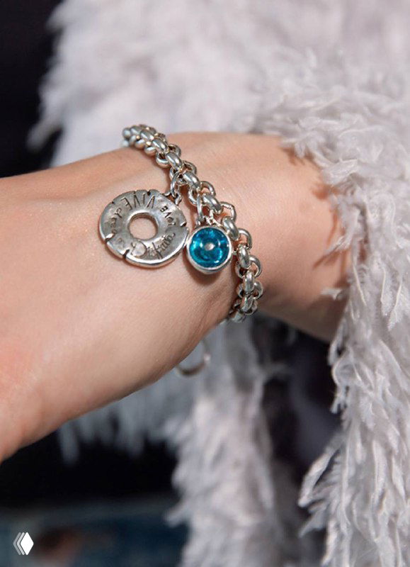 Фотография браслета Ciclon на запястье: цепочка с медальоном и бирюзовой подвеской, показ аксессуара в реальном образе на руке.