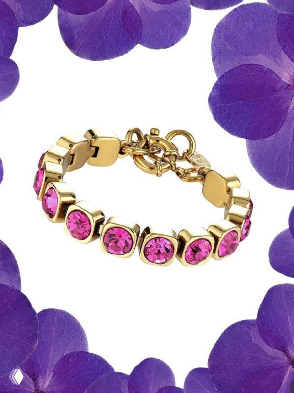 Крупный план браслета Dyrberg Kern с фуксиевыми кристаллами и золотым металлом на пастельном фоне, рекламная съёмка коллекции украшений.