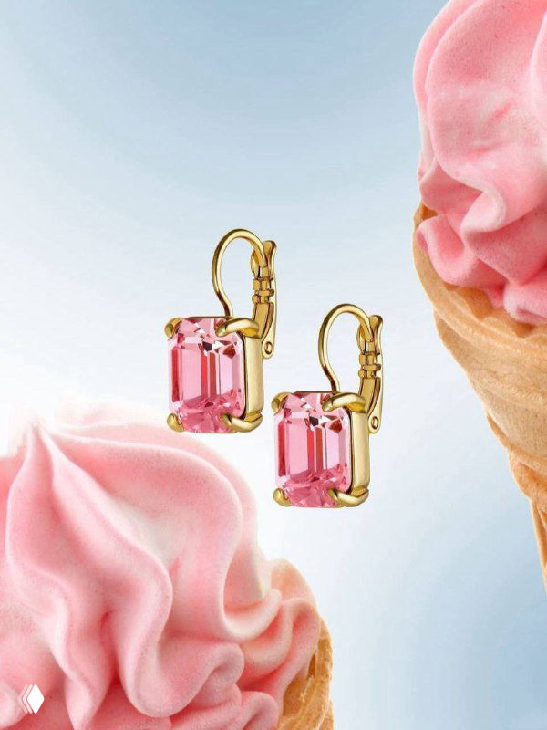 Золотые серьги Dyrberg Kern с прямоугольными розовыми кристаллами на светлом пастельном фоне рядом с декоративным мороженым, рекламный кадр.