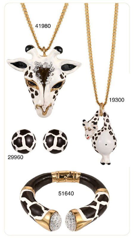Коллекция украшений с животными мотивами: крупная подвеска в виде головы животного и шармы в черно‑белой гамме, золотые браслеты и серьги рядом.