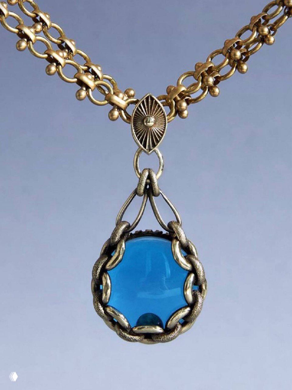 Подвес из коллекции CATENE с круглым бирюзовым кабошоном в обрамлении золотистой цепи — крупный план подвеса на нейтральном студийном фоне.