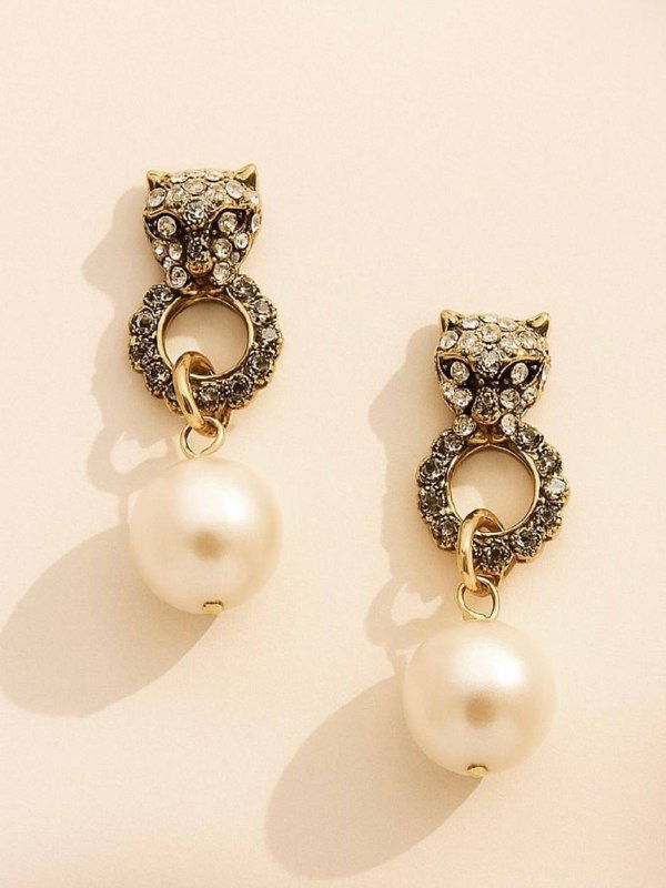 Набор украшений на ярко-розовом фоне: золотой браслет, цепочка и ряд мелких жемчужин, стилизованная предметная съёмка для витрины и каталога магазина.