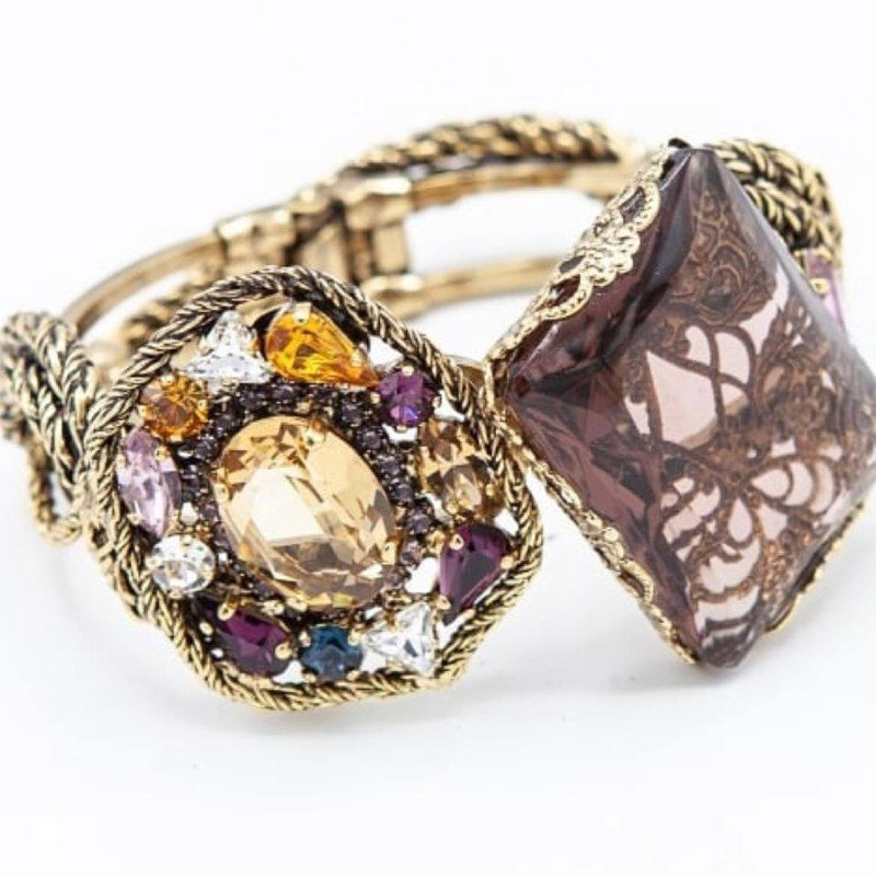 Массивный браслет с крупными цветными кристаллами и витым плетением металлической оплетки, крупный план для демонстрации текстуры и вставок.