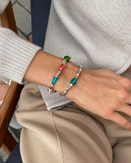 Рука и запястье с браслетом Ciclon LIQUID: сочетание серебристой цепи и вытянутых бирюзовых стеклянных элементов на повседневном образе.