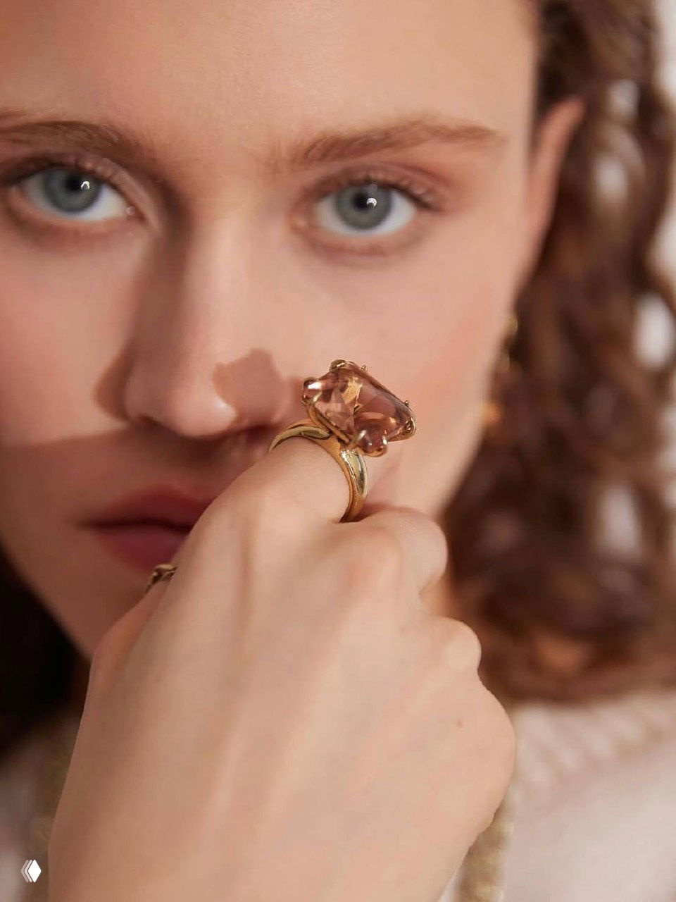Крупный портрет модели с кольцом Fiore di Firenze в золотистой оправе на пальце, мягкий свет подчёркивает текстуру камня и кожи.