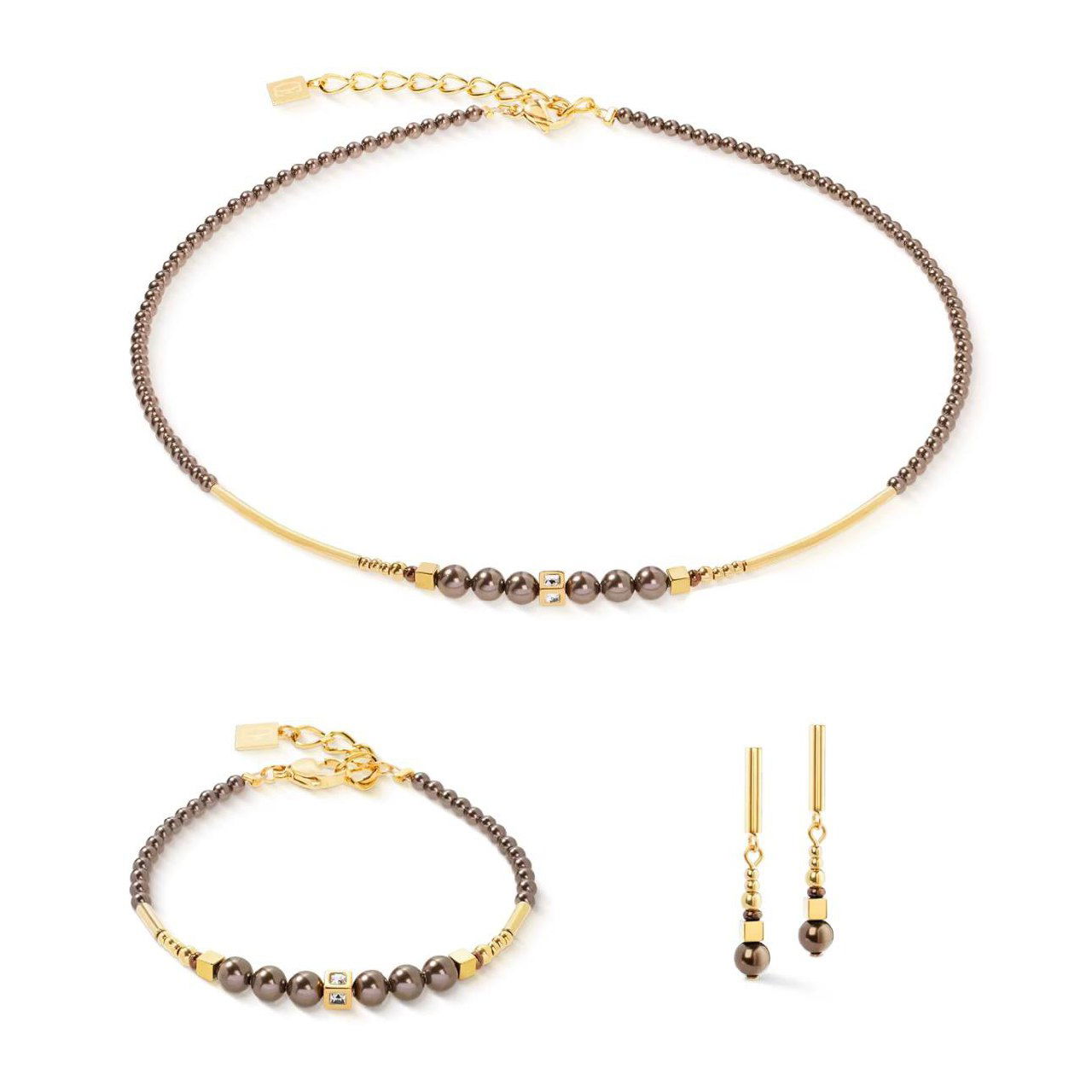 Классический комплект Coeur de Lion: тонкое колье с мелкими бусинами и браслет, дополненный подвесными серьгами в минималистичном стиле для каталога.