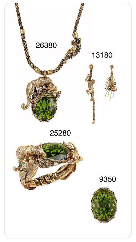 Крупный план подвески и кольца Claudio Canzian с крупным зелёным центральным камнем в золотистой оправе, артикулы видны на белом фоне