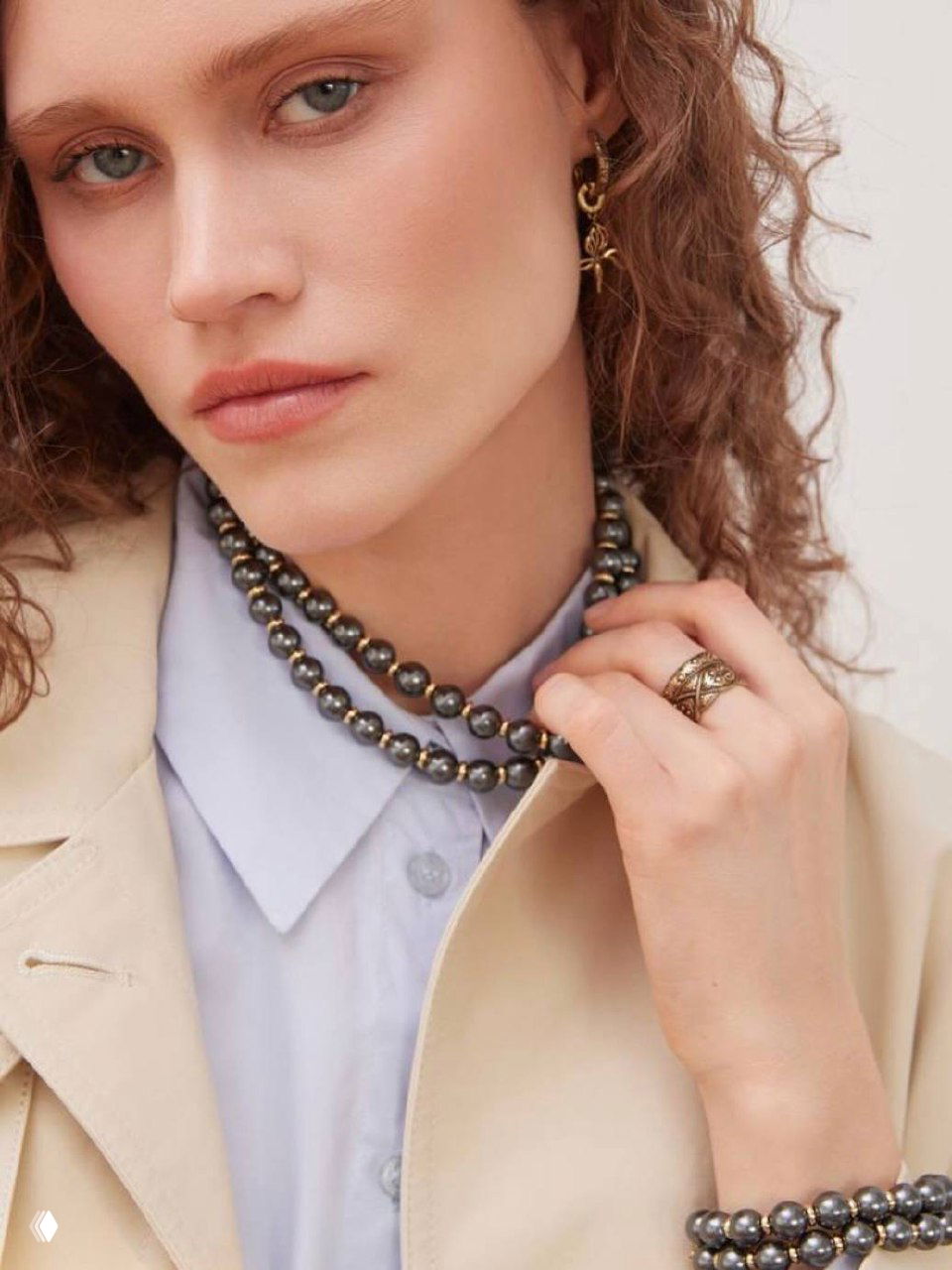 Крупный план модели в ожерелье тёмных жемчужин и кольце Fiore di Firenze — контраст жемчуга и латунного золота в винтажной стилистике.