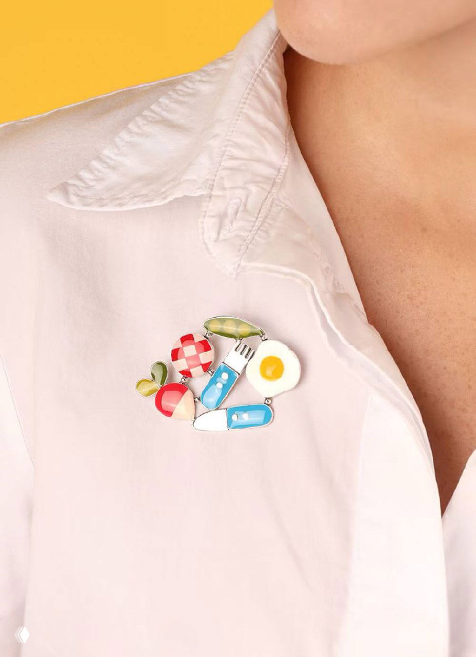 Брошь TARATATA с элементами завтрака: эмалевое яйцо, приборы и фрукты, закреплённая на воротнике рубашки — забавный дизайнерский акцент.