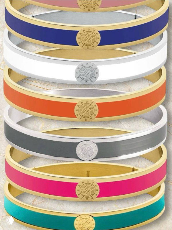 Набор ярких эмалевых бэнглов Dyrberg Kern в разных цветах с монетными медальонами, показан крупным планом.