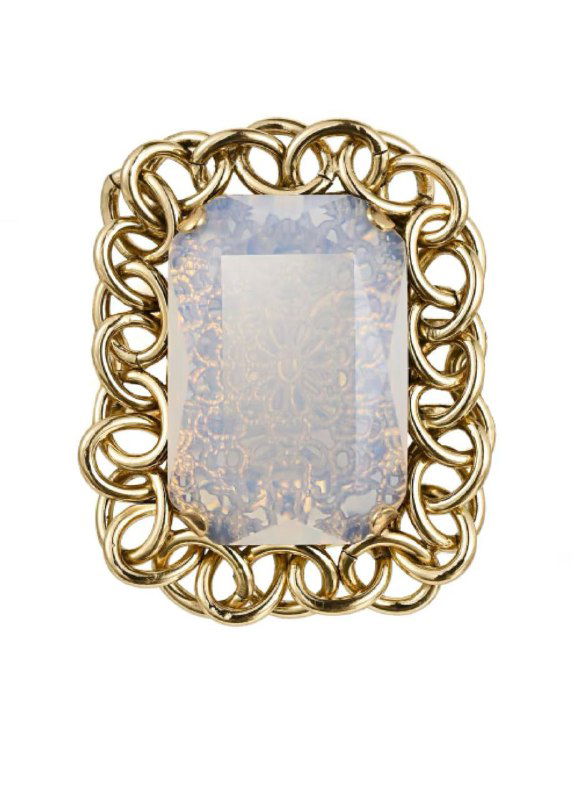 Крупный план винтажной прямоугольной броши с витой золотой рамкой и декоративной вставкой — ретро-деталь для вечернего или праздничного образа.