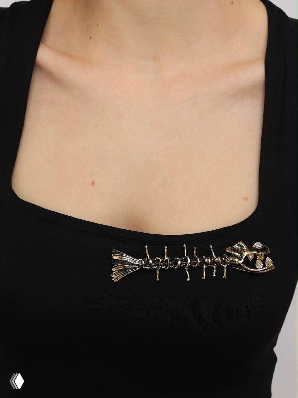 Брошь в виде скелета рыбы на чёрной одежде — авангардный дизайнерский аксессуар, подчёркивающий смелый нестандартный стиль и индивидуальность владельца.