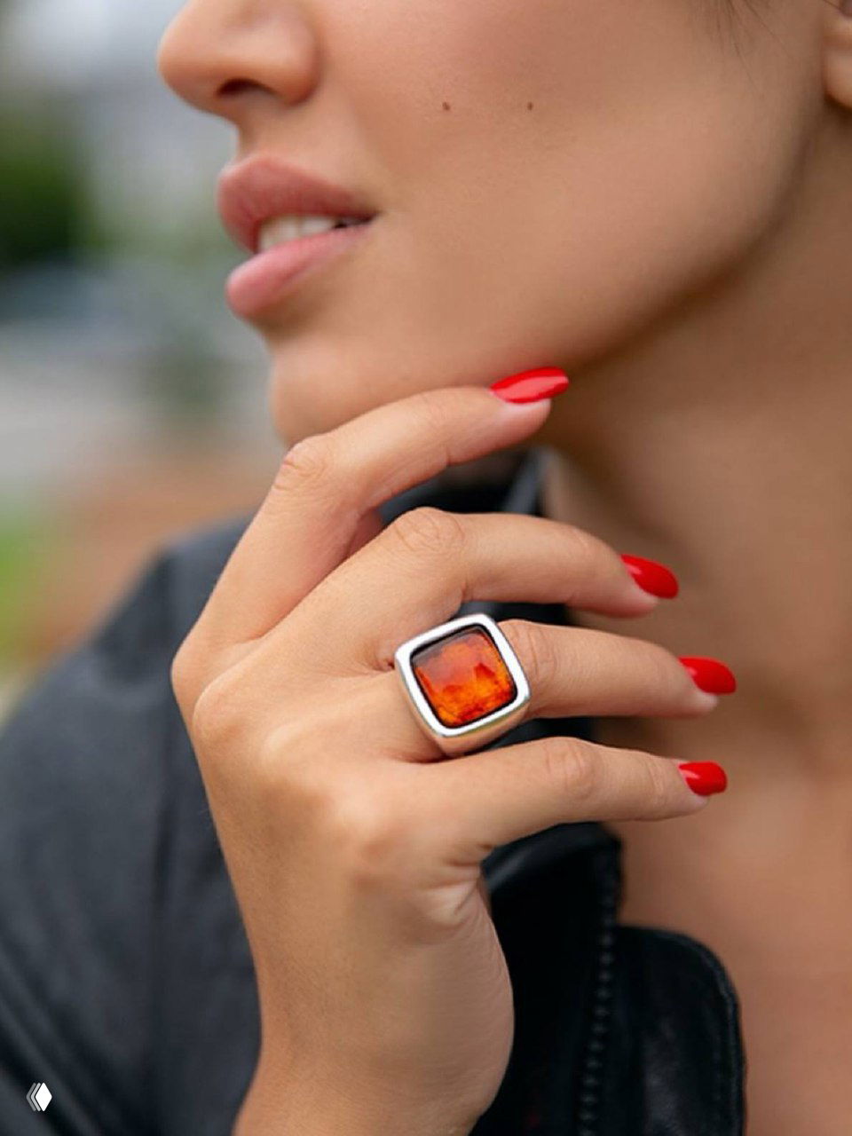 Кольцо KUBIK от Ciclon на пальцах модели: квадратный янтарно-коричневый камень в широкой серебряной оправе, акцент на маникюре.