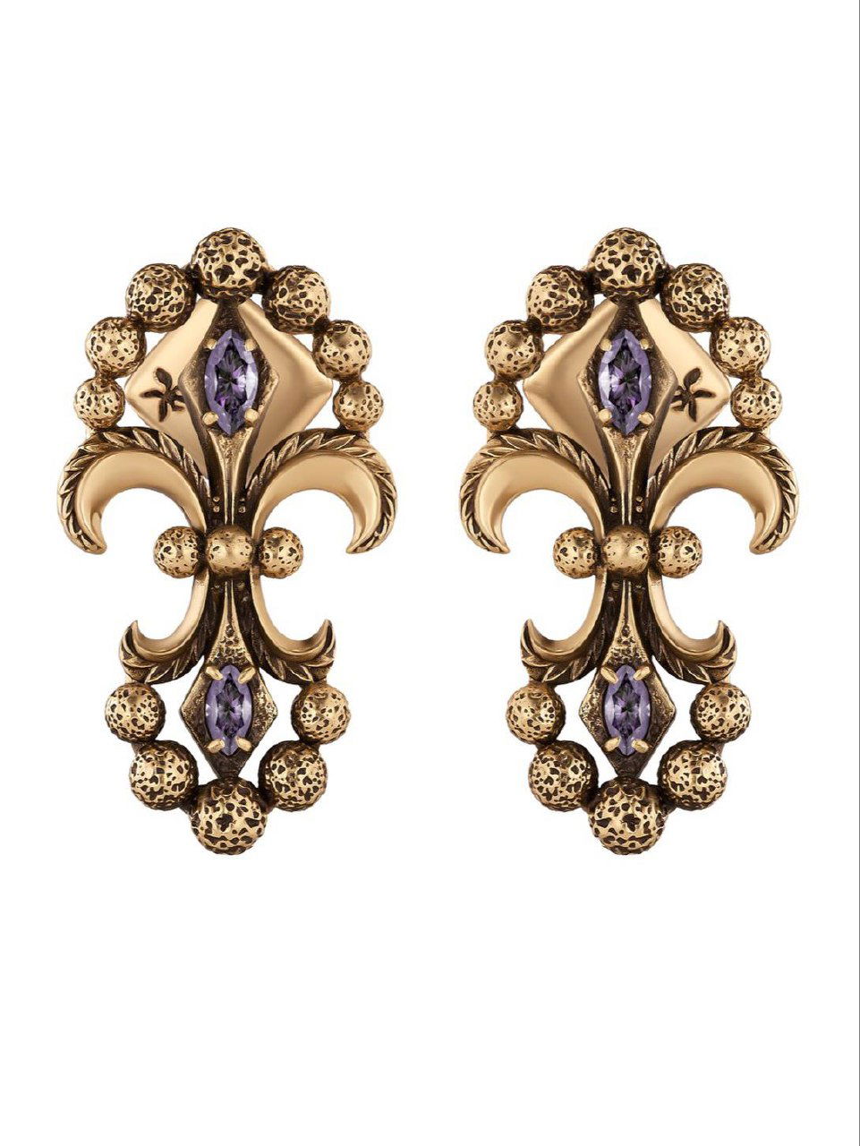 Крупный план парных серёг IRIS ARALDICO NOVA на белом фоне: золотистые формованные элементы флёр-де-лис, фактурные шарики и фиолетовые кристаллы в центре украшения.