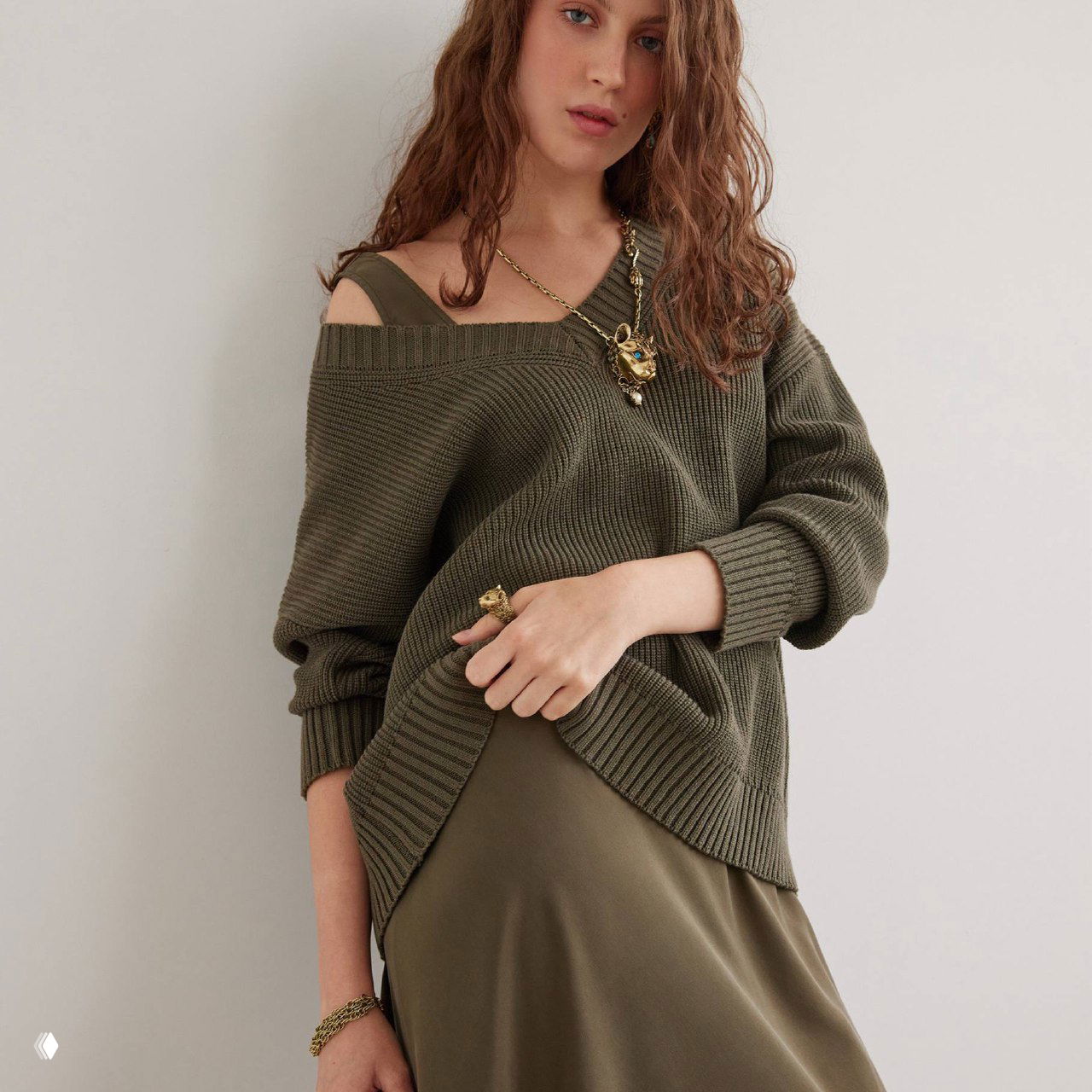 Модель в повседневном образе в зелёной одежде, на шее виднеется кулон-пума и на руке — кольцо из новой осенней коллекции Fiore di Firenze.