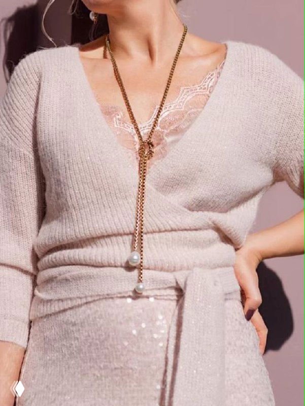 Длинное позолоченное колье-галстук с двумя жемчужинами на концах, уложенное на белом фоне — вариант на вечер и офисный образ.