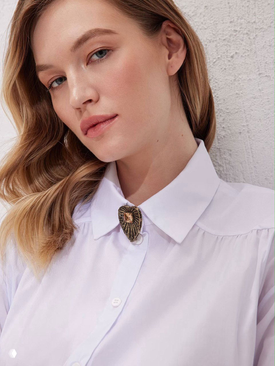Модель в белой рубашке с брошью на воротнике — пример как носить брошь на офисной рубашке, портретный снимок