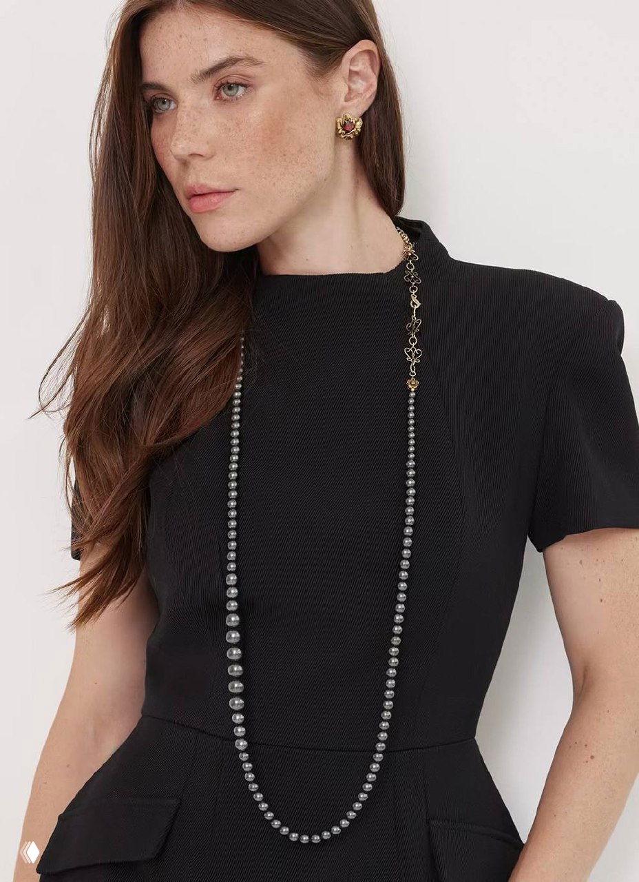 Портрет модели в чёрном платье с длинной жемчужной цепью Fiore di Firenze, контрастный образ с деловым акцентом.