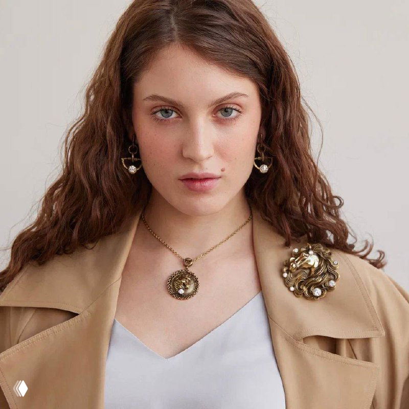 Модель в бежевом пиджаке с кулоном Cavallo и брошей в винтажном стиле: снимок образа коллекции Fiore di Firenze для презентации комплекта украшений в магазине Rosone.