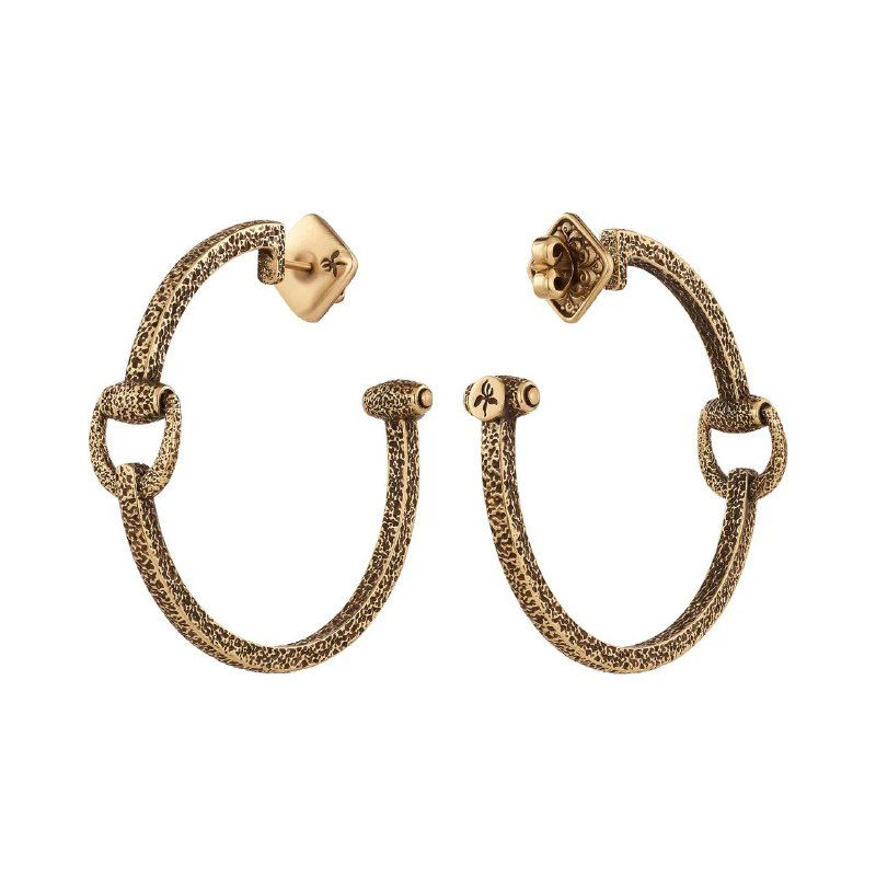 Пара золотистых полу-кольцевых сережек с текстурой и креплением гвоздикой, вид на белом фоне — изделие коллекции Fiore di Firenze Cavallo для каталога Rosone.