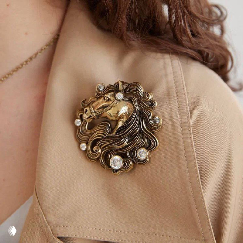 Брошь коллекции Cavallo крупным планом: рельефная голова лошади, инкрустация стразами и винтажный золотистый оттенок, фотография для каталога и образов Rosone.