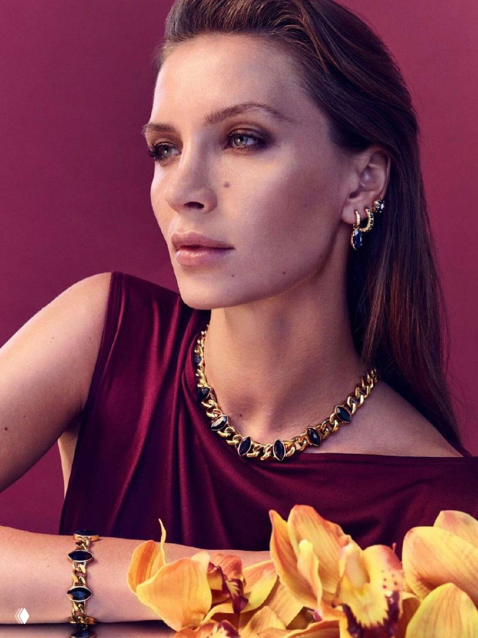 Трёхчетвертной портрет модели в бордовом топе с крупным золотым ожерельем, браслетом и серьгами DYRBERG KERN — рекламная съёмка коллекции.