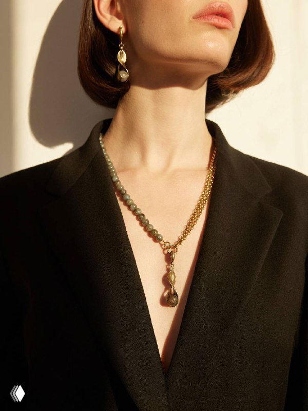 Модель в тёмном пиджаке демонстрирует ожерелье Fiore di Firenze с подвеской, акцент на линии шеи и элегантной форме украшения.