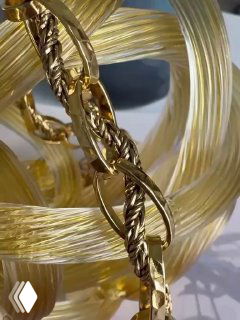 Крупный план золотой цепочки и текстуры звеньев: качественная фурнитура и витая плетёная композиция характерная для коллекций бренда.