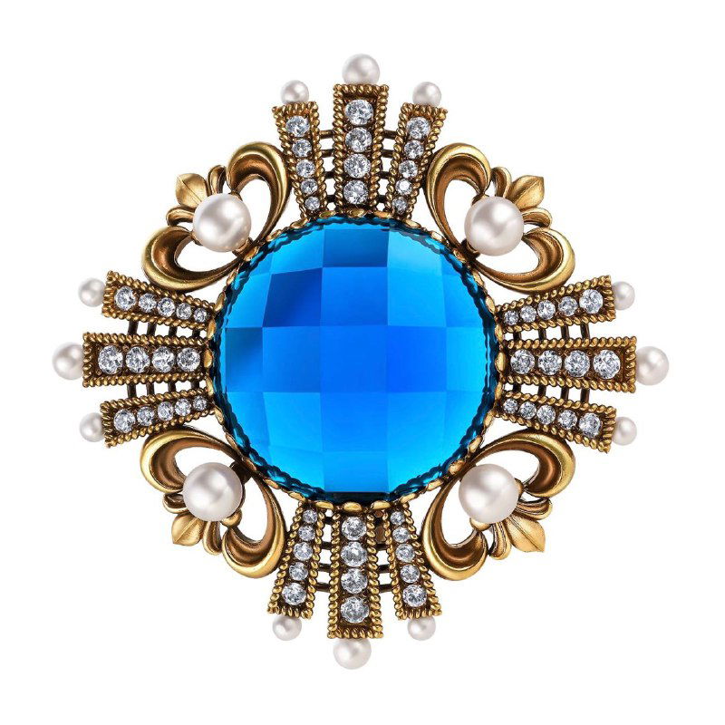 Круглая винтажная брошка с большим голубым кристаллом и жемчужными вставками на золотистой основе, демонстрация яркого акцента для образа.