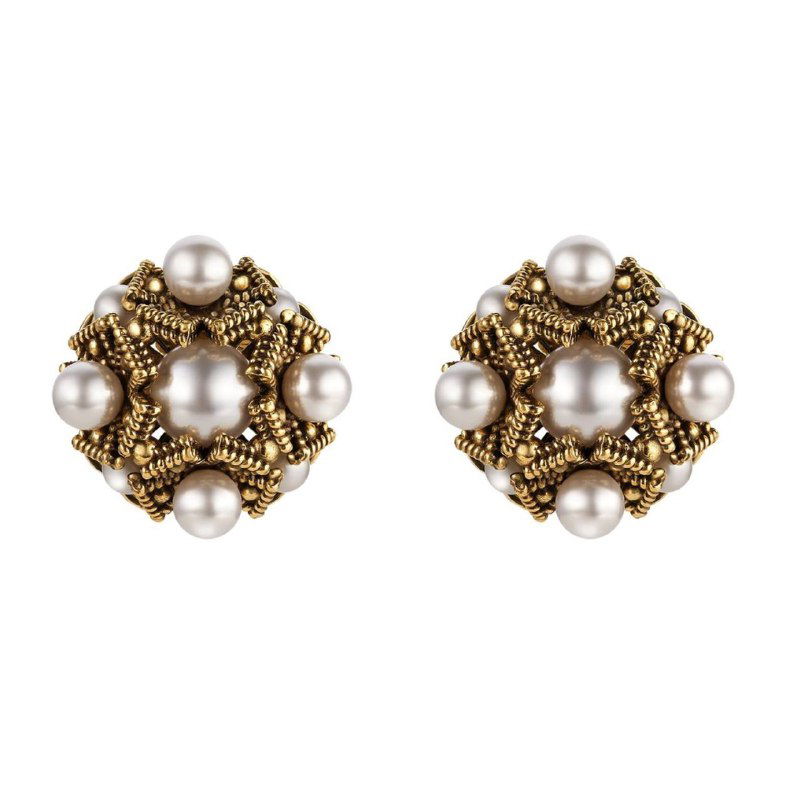 Крупный план круглых клипс-серьг Fiore di Firenze: декор из жемчуга, сложная позолоченная филигрань и декоративные бусины на белом фоне.