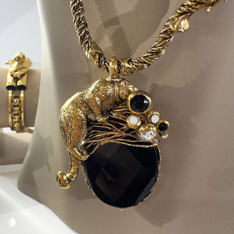 Детальная фотография золотого кулона с крупным чёрным камнем и декоративной фигуркой, часть новых дизайнерских украшений Claudio Canzian.