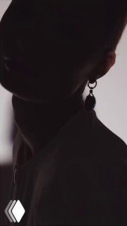 Темный силуэт в профиль с крупным акцентом на серьге из коллекции CATENE — контрастная студийная фотография для каталога.