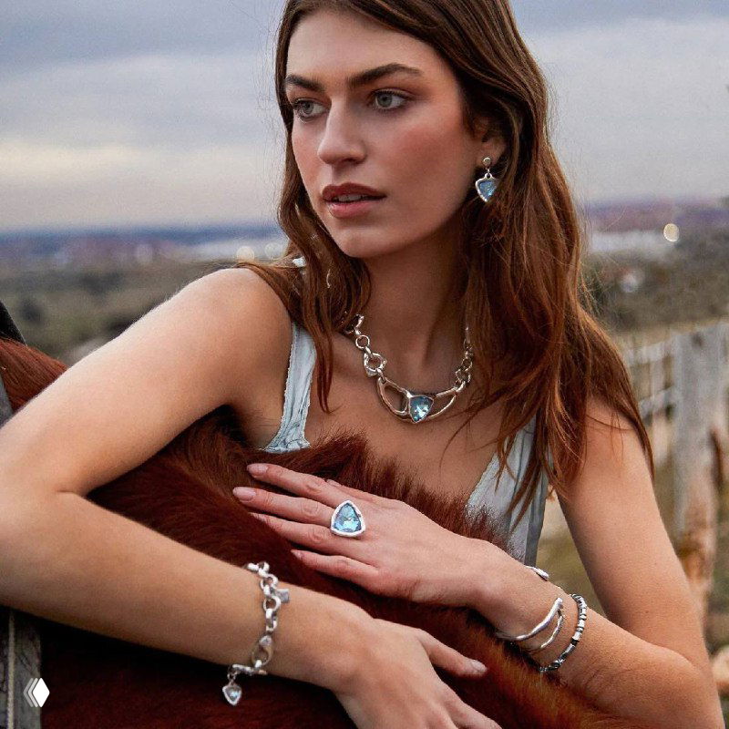 Модель в украшениях VIDDA: колье, серьги и кольцо с крупными голубыми кристаллами Swarovski, образ снят на открытой террасе