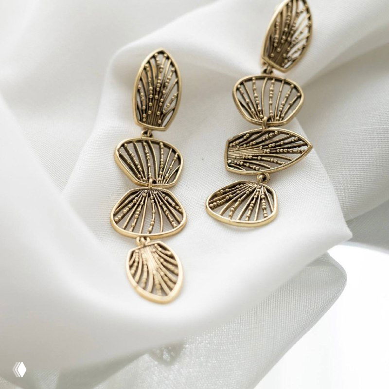 Длинные серьги-ламели из золотистого металла выложены на белом фоне, детальное отображение форм и текстуры в винтажном стиле Fiore di Firenze.