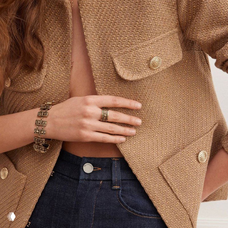Рука модели в бежевом жакете показывает кольцо и браслет из коллекции: сочетание нейтральной одежды и изящной бижутерии Fiore di Firenze.