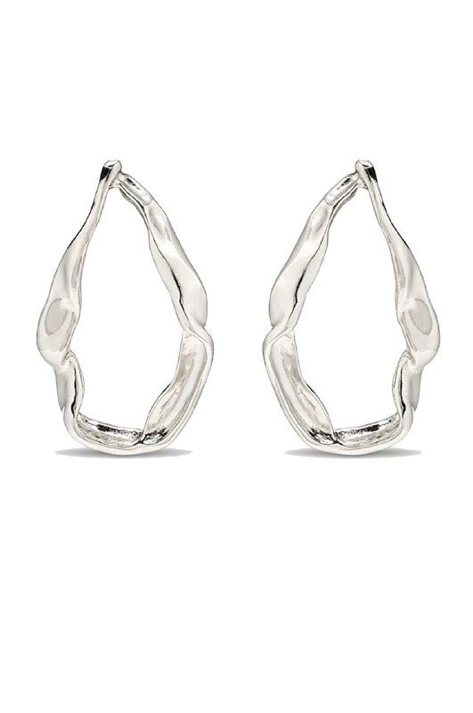 Серебристые фактурные серьги каплевидной формы на белом фоне — плавные неровные контуры и отражающий металлический блеск на изделии.