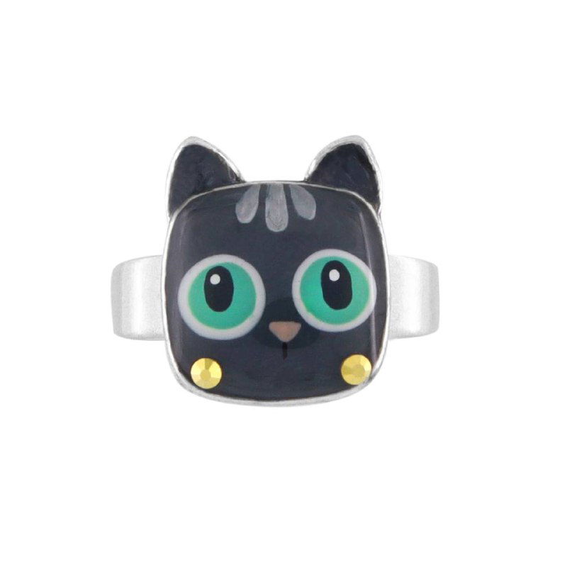 Кольцо TARATATA в виде мордочки чёрного кота с зелёными глазами и эмалевыми деталями на белом фоне, детская и игривая эстетика украшения.