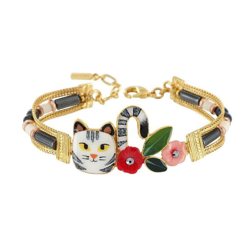 Браслет TARATATA с эмалевыми мотивами и фигурой бело‑рыжего кота, золотистые элементы и цветочные детали на белом фоне, декоративный аксессуар.