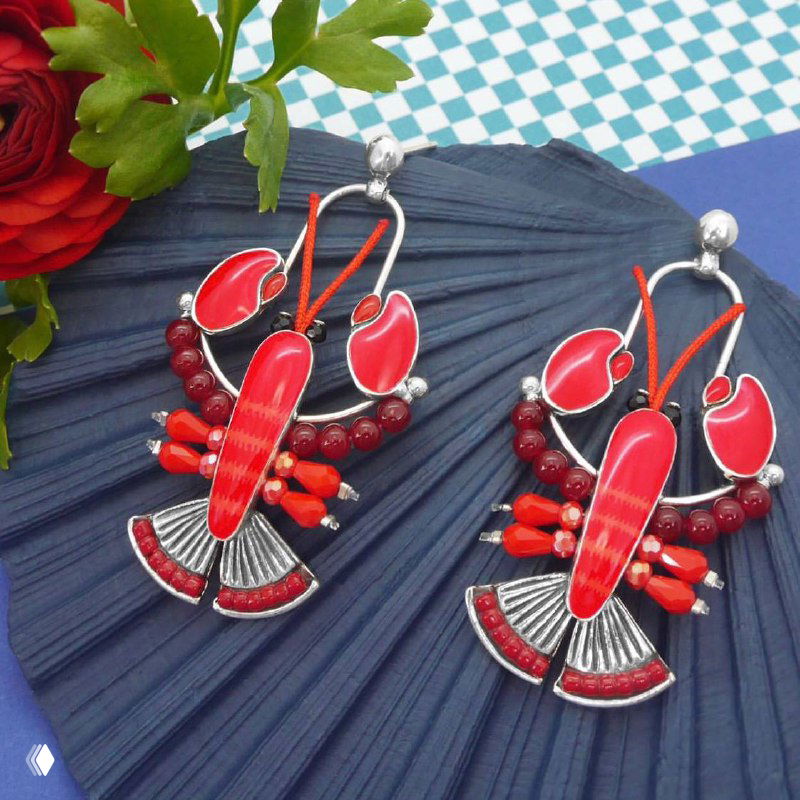 Крупные серьги TARATATA красного цвета с коралловыми элементами на тёмно‑синем фоне и декоративной цветочной композицией, эффектный праздничный дизайн.