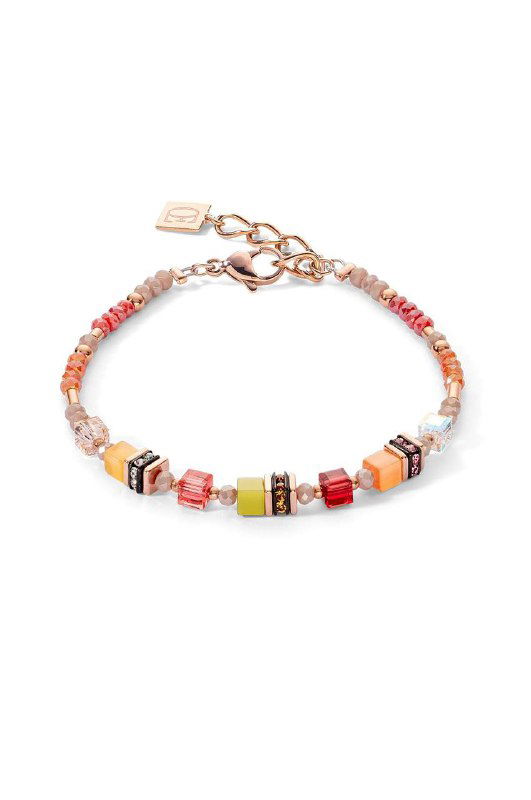 Тонкий браслет с яркими мелкими бусинами и акцентными цветными элементами крупным планом на светлом фоне, летний и лёгкий аксессуар.