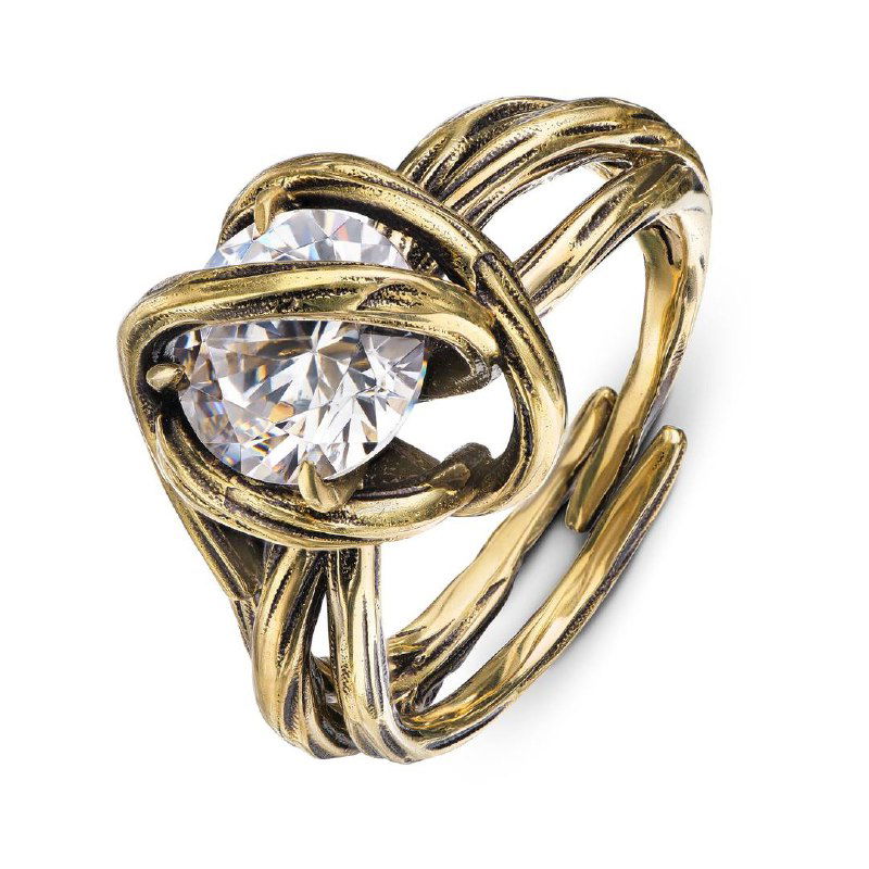 Студийный снимок кольца CORDA с крупным прозрачным кристаллом, золотистый сплав и переплетённые ленты на белом фоне