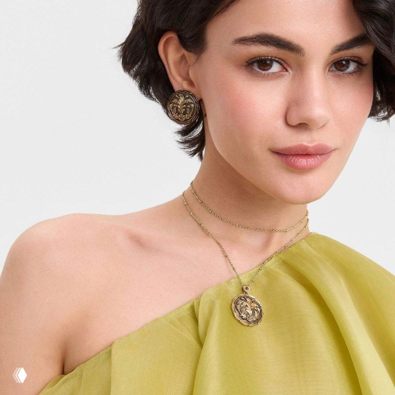Портретная съёмка модели в светло-зелёном платье с медальонным кулоном и серьгами Fiore di Firenze, подчёркнуты линии шеи и аксессуары
