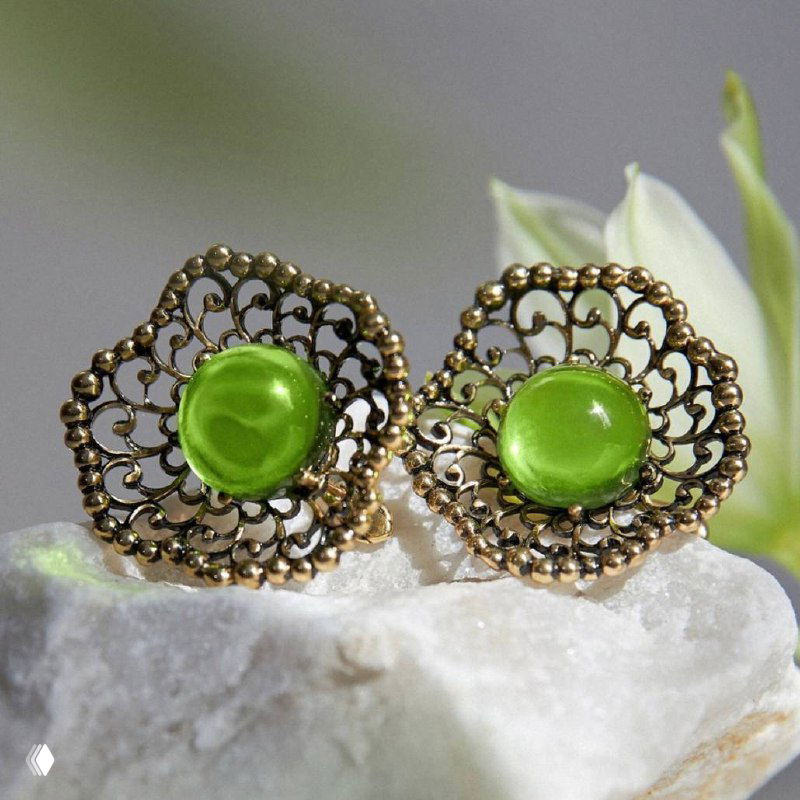 Пара изящных ажурных серьг с яркими зелёными кабошонами Fiore di Firenze на нейтральном каменном фоне — детальное фото для каталога