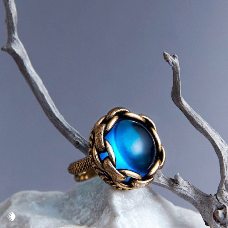 Крупный план кольца с насыщенной синей вставкой в массивной золотистой оправе Fiore di Firenze на стилизованной ветке — акцент на цвет и форму