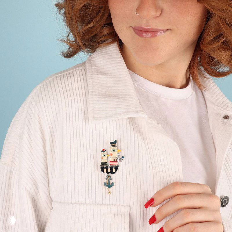 Фотография модели, демонстрирующей брошь TARATATA, закреплённую на белой рубашке — показан размер и стиль аксессуара в образе.