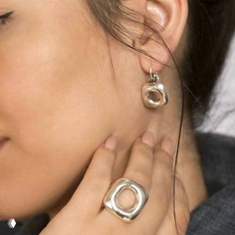 Крупный план серьги и кольца на модели: круглые органичные формы украшений Ciclon, мягкий портретный кадр для демонстрации посадки.