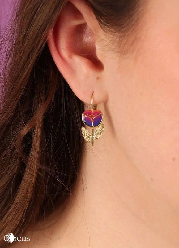 Серьга TARATATA в виде фиолетово-красного сердечка с золотистыми деталями на ухе модели, демонстрация посадки и размера украшения.