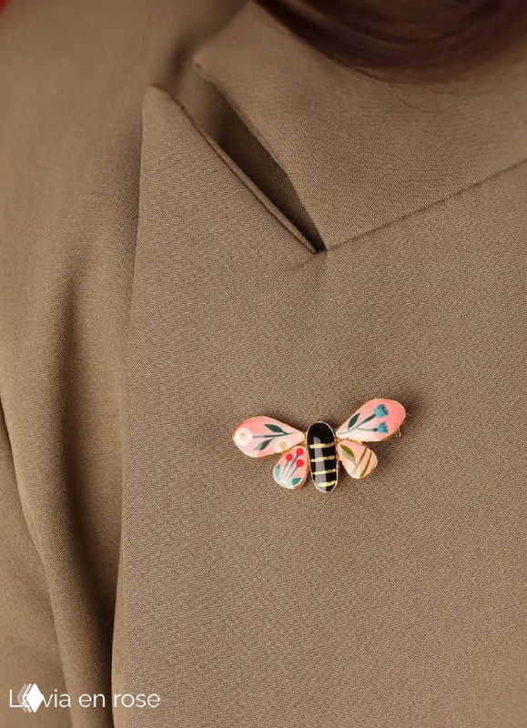 Небольшая брошка в виде насекомого с пастельной эмалью на лацкане пальто модели, демонстрация декоративной броши из коллекции La via en rose.
