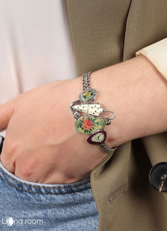 Браслет TARATATA с несколькими разноцветными эмалевыми подвесками на запястье модели, показ сочетания форм и посадки аксессуара.